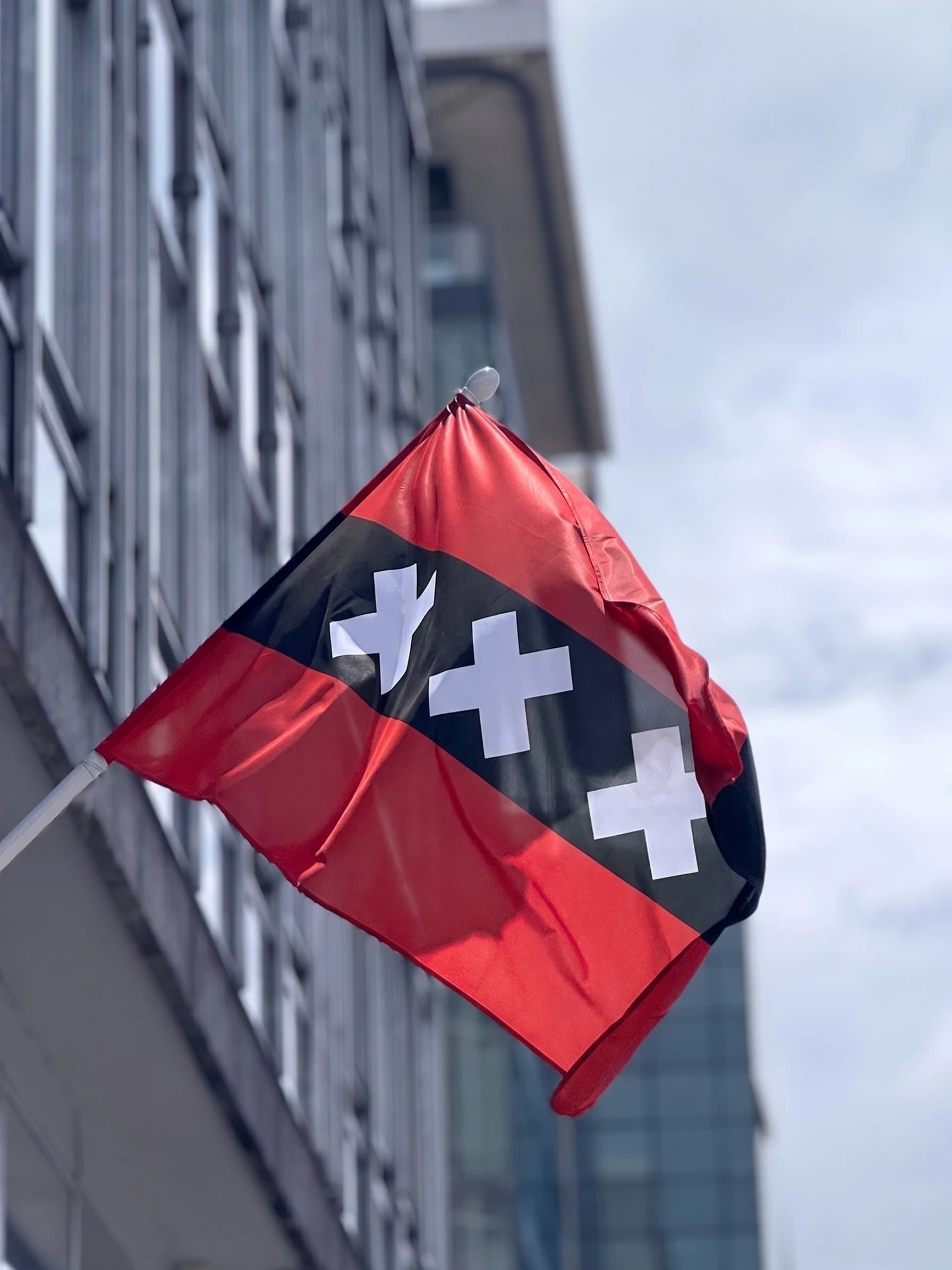 Amsterdam flag, red and black with three white crosses, in Hemptex® hemp on a building facade pole