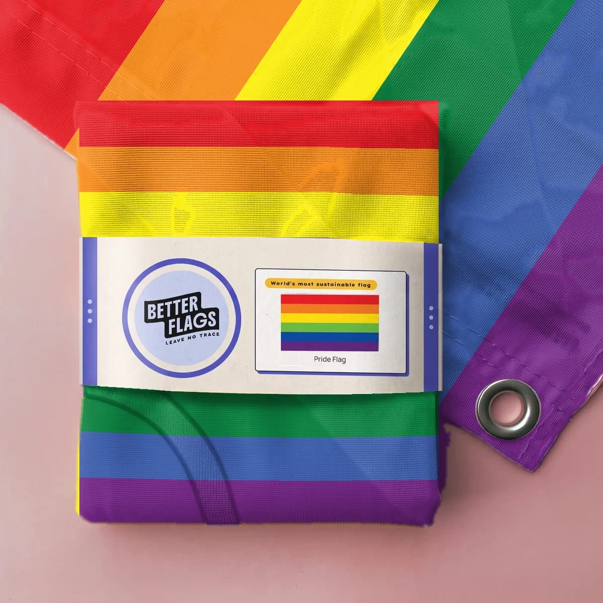 Folded rainbow Pride flag wrapped in a paper Better Flags band (packaging mockup)
