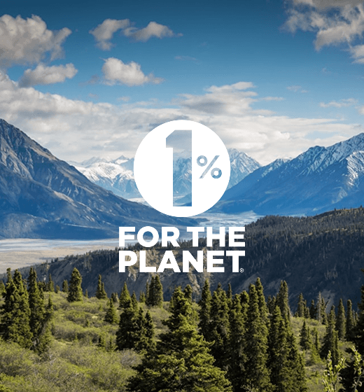 Better Flags | CiCLO Flags | Mountain landscape with pine trees in the foreground under a partly cloudy sky, overlaid with a white circle containing the text '1%' and below it 'FOR THE PLANET'.
